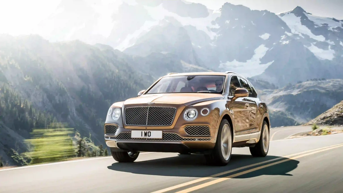 Bentley Bentayga luxury SUV driving on a mountain road with scenic alpine peaks in a cinematic 4K wallpaper
