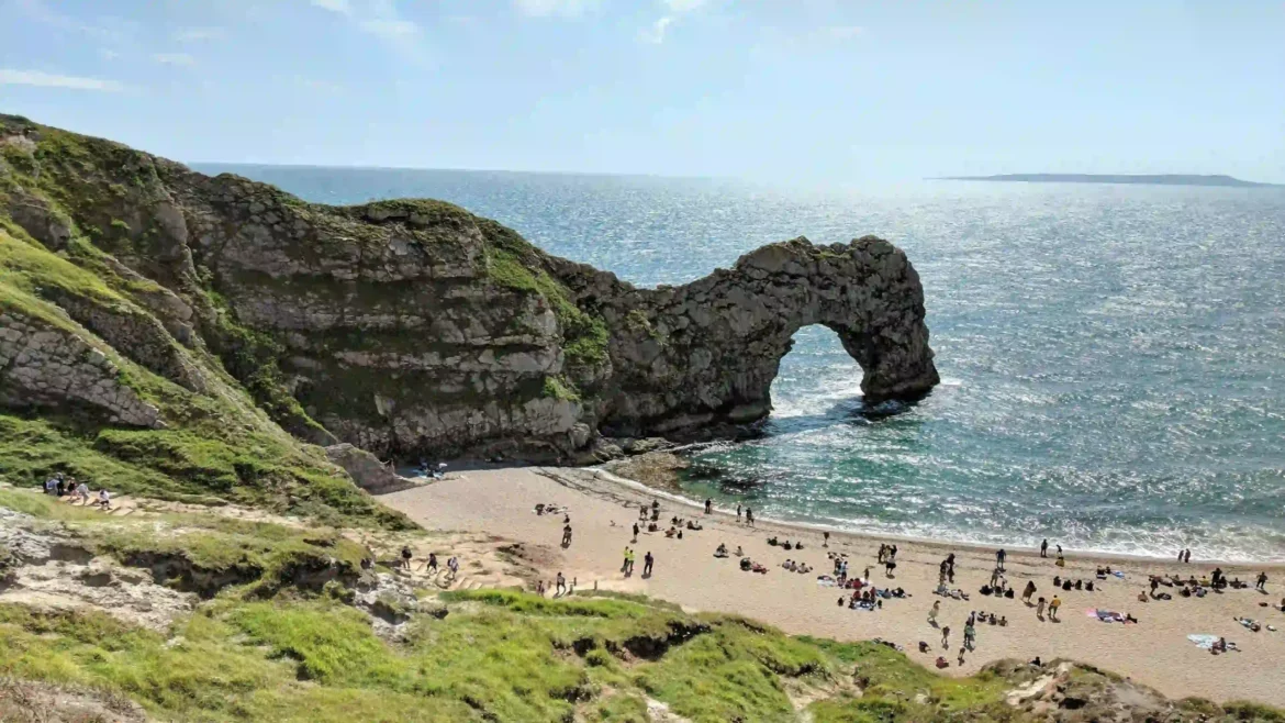 Durdle Door 4K wallpaper featuring the famous limestone sea arch, sandy beach, turquoise waters, and dramatic cliffs on England's Jurassic Coast