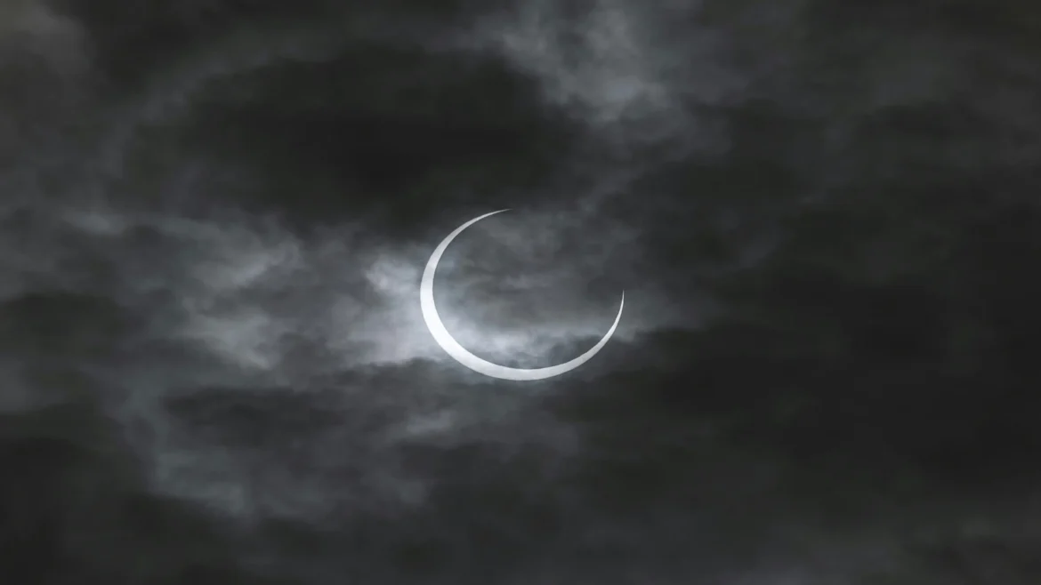 Bright crescent moon glowing through dark storm clouds in the night sky, celestial 4K Ultra HD wallpaper