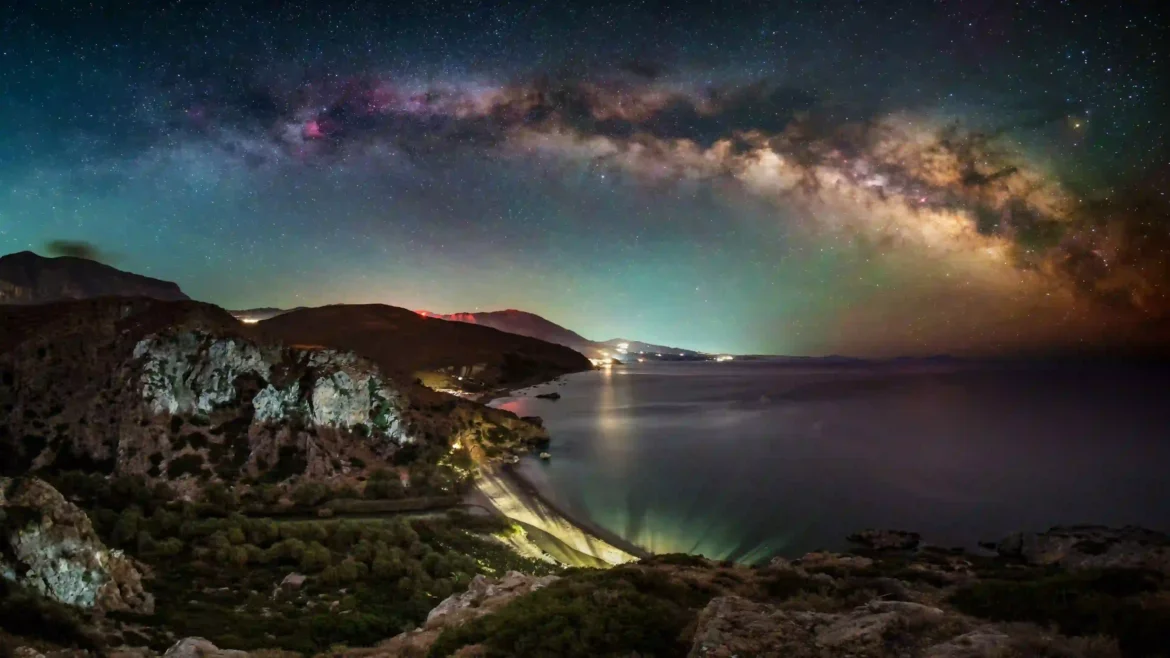 Milky Way galaxy arch stretching across a star-filled sky above rugged coastal cliffs and calm ocean waters in an Ultra HD 4K wallpaper