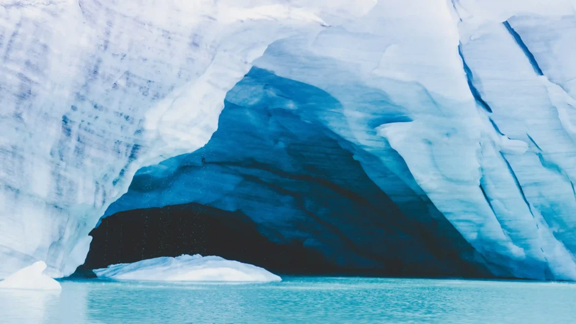 Towering blue glacier ice surrounding a calm turquoise lagoon inside an Arctic ice cave in an Ultra HD 4K nature wallpaper