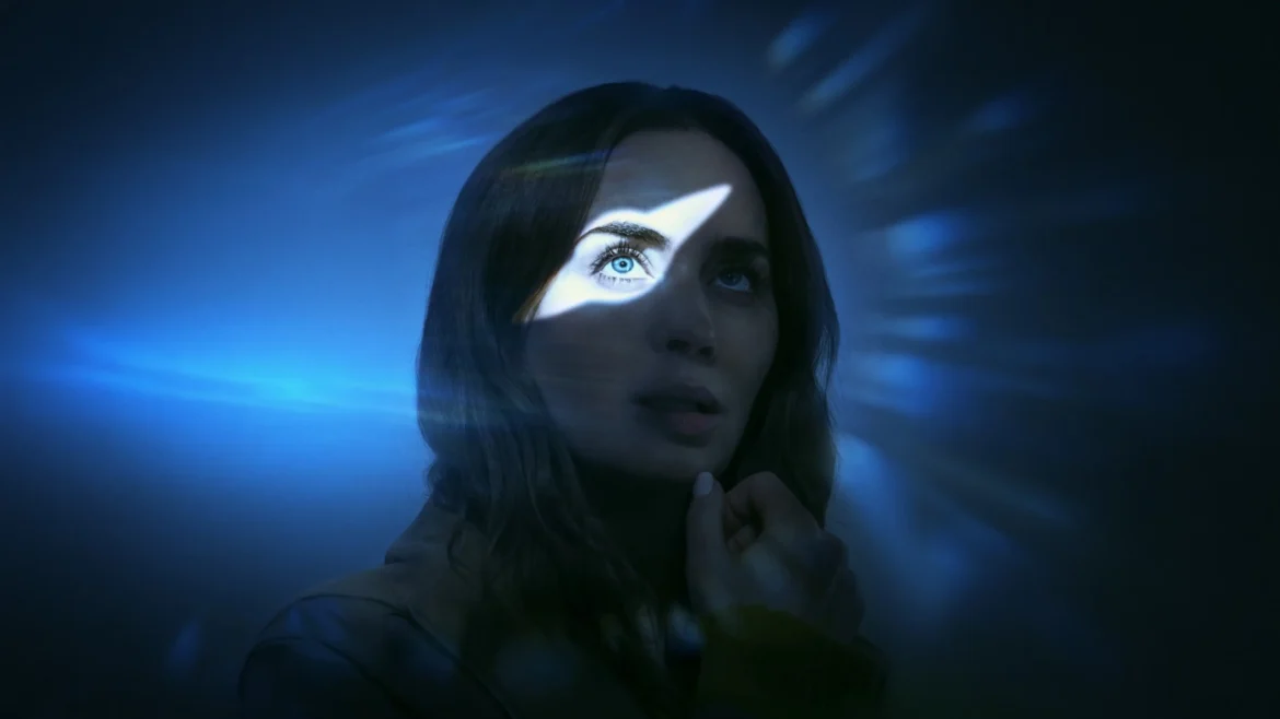Emily Blunt illuminated by a dramatic beam of blue light across her eye in a sci-fi 4K wallpaper