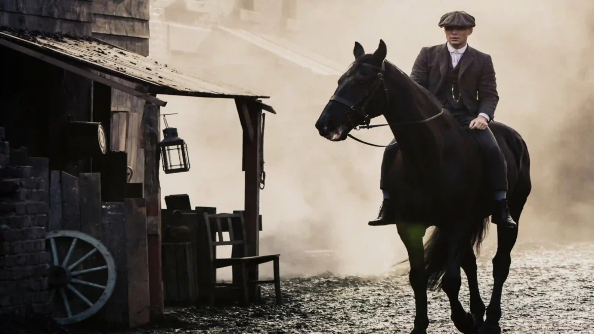 Tommy Shelby riding a black horse through a foggy industrial street in a cinematic Ultra HD 4K Peaky Blinders wallpaper