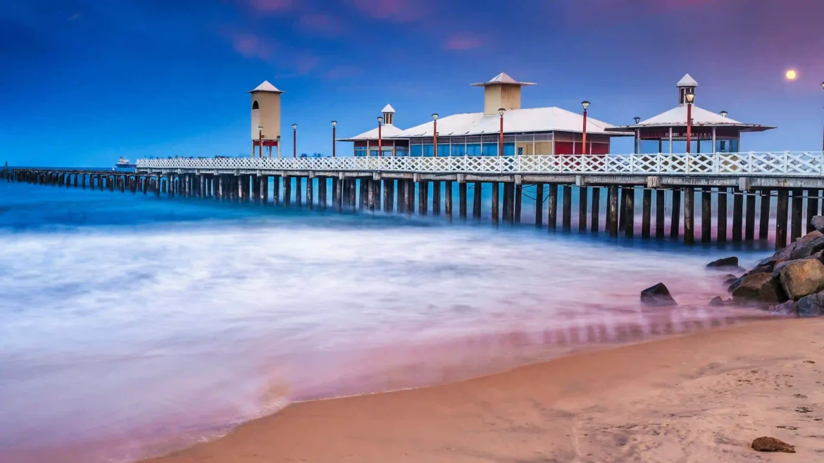 Puducherry pier extending into misty ocean waves under a twilight sky in a high-resolution 4K wallpaper