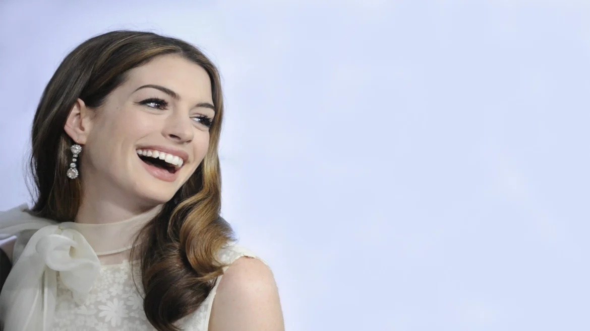 Anne Hathaway laughing in a white lace dress with sparkling diamond earrings in a 4K celebrity wallpaper