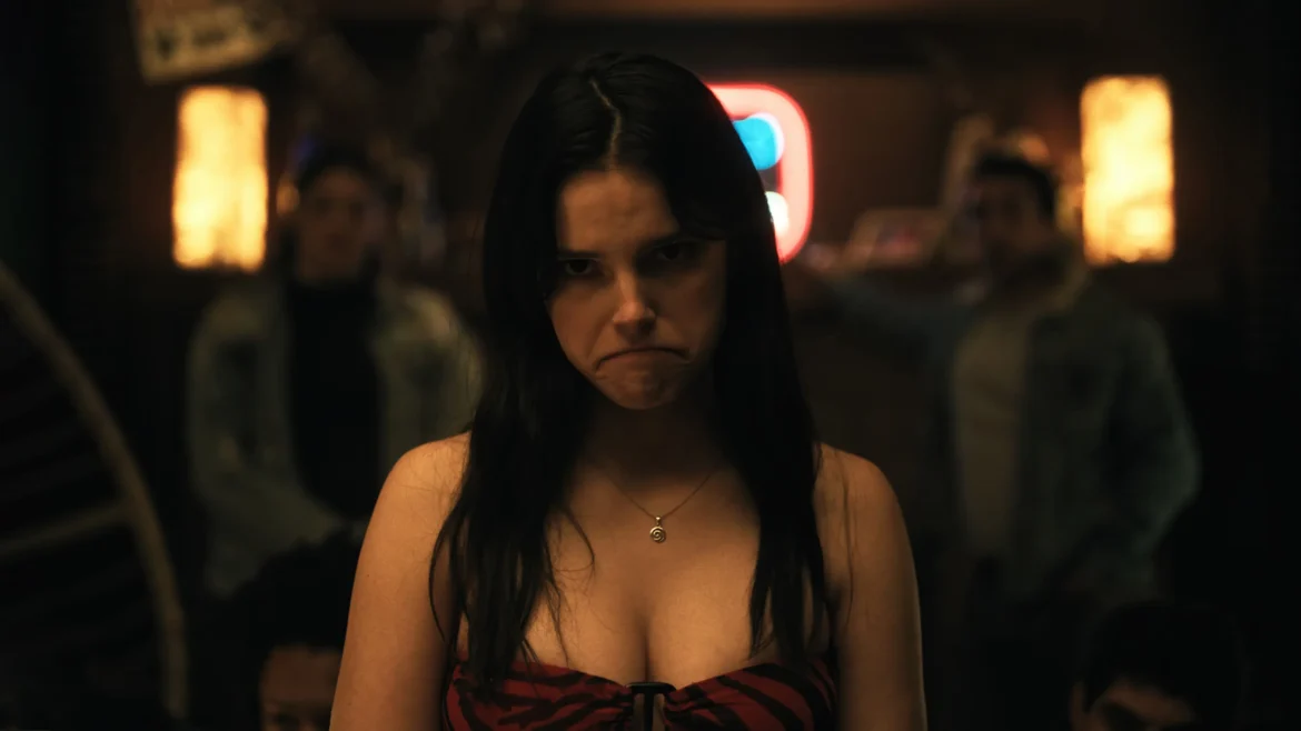 Nikki from Obsession making a sad pouty expression in a red striped top in a 4K dark thriller movie wallpaper